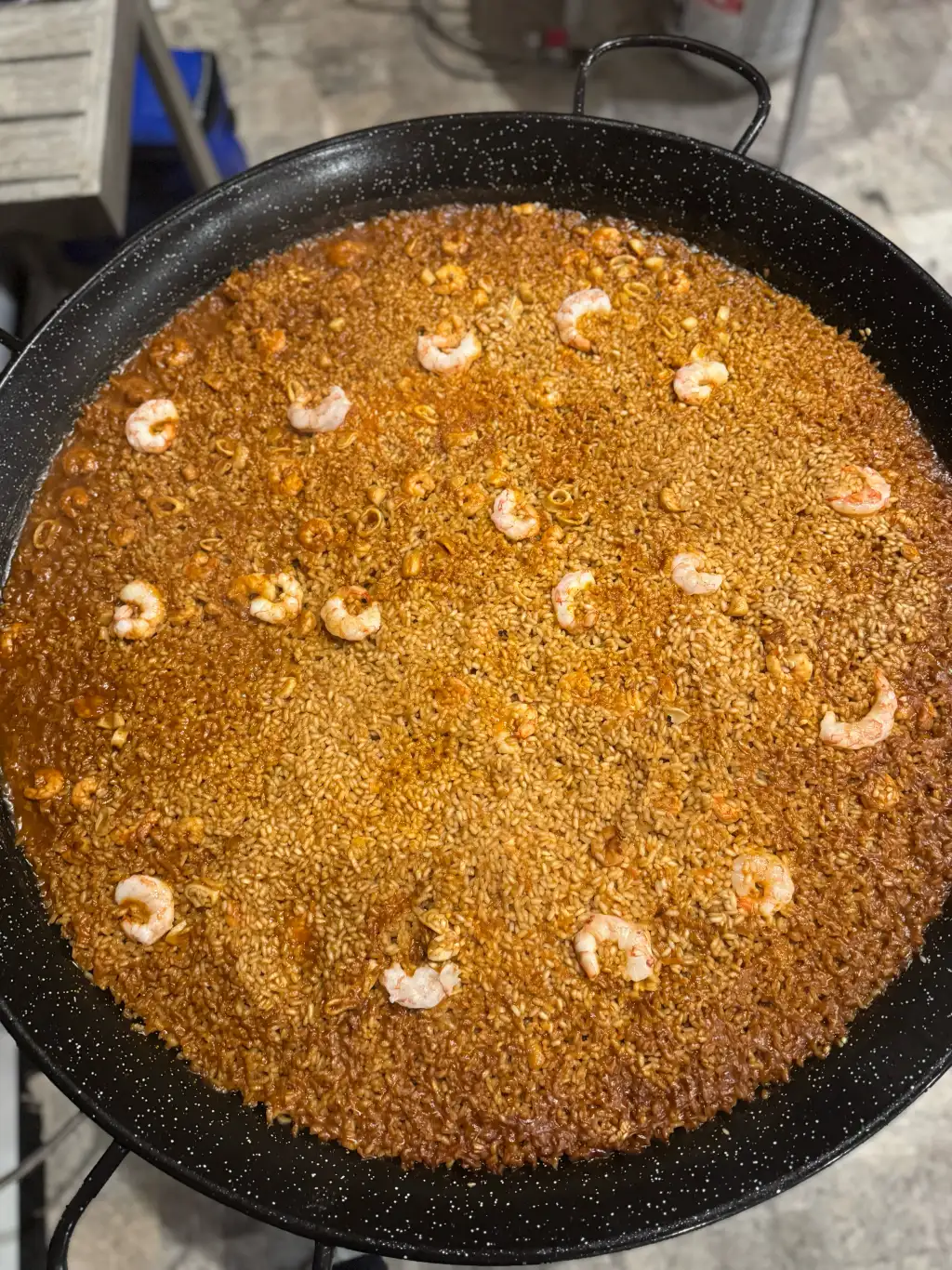 Vista cenital de una paella mostrando la capa de socarrat caramelizado al fondo de la sartén